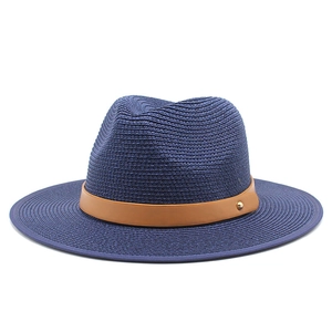 Detail of navy straw fedora hat featuring a brown leather band and gold buckle