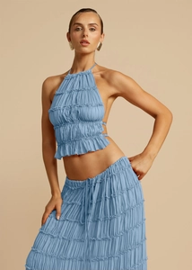 Detail of blue backless halter top and tiered ruffle skirt set in pleated fabric