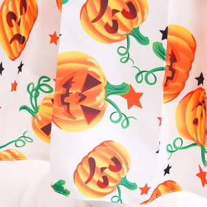 Detail of Halloween girl dress fabric with pumpkin print and quality stitching on hem