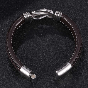 Detail of a brown woven leather bracelet with a silver metal knot and magnetic clasp