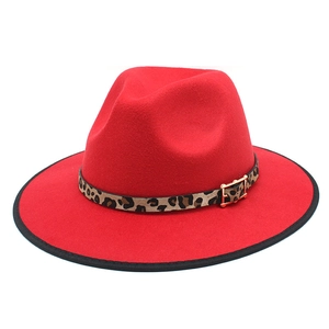 Detail eines roten Fedorahuts mit Leopardenmuster-Band und goldener Metallschnalle