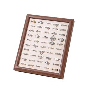 Walnut wood jewelry tray with velvet lining displaying various vintage rings at 45-degree angle