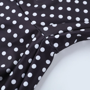 Détail macro des coutures de haute qualité sur un pantalon extensible à pois noirs