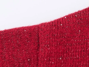 Vue macro du tissu tricoté rouge avec paillettes argentées et texture dense
