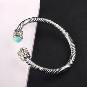Detailed macro view of cable wire bangle featuring turquoise stones and crystal accents
