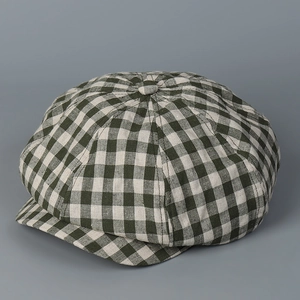 Close-up of vintage green and white gingham newsboy cap with linen texture and top button