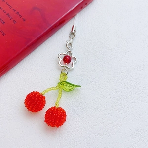 Detail of handmade cherry bead pendant with silver flower charm and crystal lobster clasp