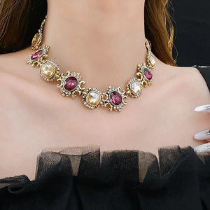Detail of vintage gold necklace with purple and yellow crystals on model in black lace