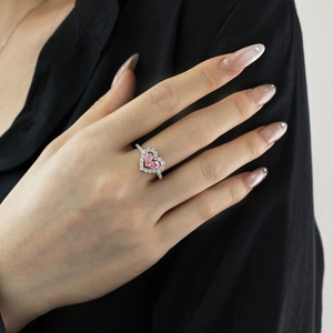 Detailed close-up of a heart-shaped pink zircon ring worn on a model's hand