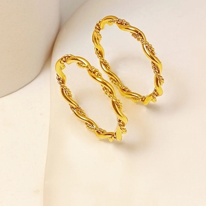Detailed macro view of two gold twisted rope rings showing intricate braided metal texture