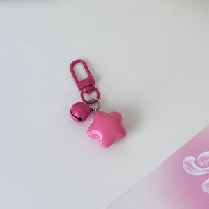 Detail of pink star-shaped keychain with matching bell and durable D-ring clasp