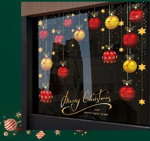 Detail of Christmas window clings with red and gold baubles and festive typography
