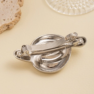 Detailed macro view of the silver metal hair clip spring mechanism and polished texture