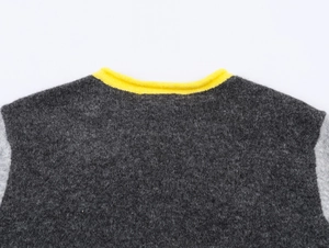 Detail of color-block knit cardigan featuring a yellow ribbed collar and grey wool texture