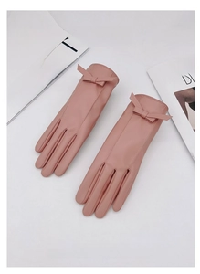 Dettaglio di guanti in pelle PU rosa con elegante fiocco e morbida fodera termica