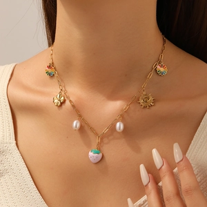 Colorful pendant necklace with strawberry, sunflower and pearl charms on model