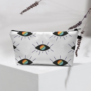 Waterproof travel makeup bag with rainbow evil eye pattern on a canvas toiletry case