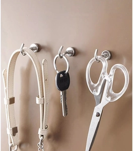 Heavy-duty magnetic hooks holding tools on a metal surface with strong silver metallic texture