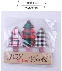 Close-up of wood Christmas tree ornaments with plaid patterns and Joy to the World base