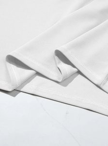 Close-up of breathable mesh texture and double-stitched hem on a white polo shirt
