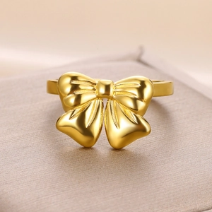 Close-up of a polished gold bow ring showcasing refined metallic luster and detail