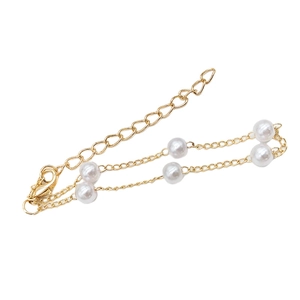 Detail of gold-plated chain bracelet with white pearls and adjustable lobster clasp closure