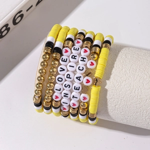 Close-up of colorful polymer clay bead bracelets with TEACH and LOVE letter beads