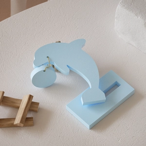 Minimalistisches hellblaues Delphin-Ornament mit Goldkette und Holzsockel-Detail