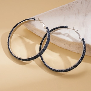 Chic denim wrapped silver hoop earrings displayed on a white marble stone surface