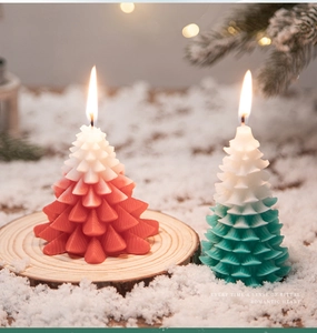 Detail of red and green gradient Christmas tree scented candles on wooden base with snow