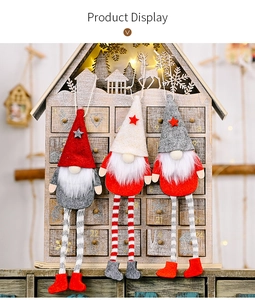 Detailed view of three hanging Christmas gnomes with striped legs on wooden backdrop