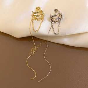Détail de manchettes d'oreilles or et argent élégantes avec perles, strass et glands longs