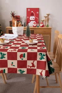 Detailed Christmas tablecloth with reindeer and red plaid pattern on a festive dinner table