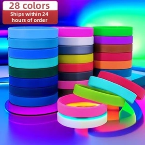 Macro display of 28 vibrant silicone wristbands in diverse colors with elastic texture