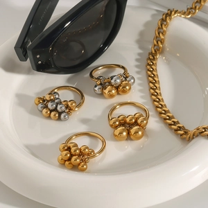 Anelli di perline oro e argento minimalisti e catena cubana spessa su vassoio bianco