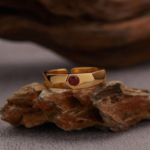 Detailed close-up of a gold S925 silver garnet ring placed on a natural rock texture