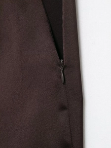 Macro detail of high-quality matching matte zipper on brown satin fabric clothing