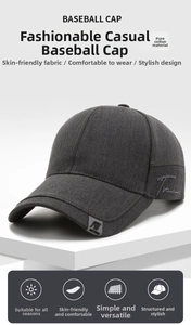 Detail of dark gray cotton baseball cap with intricate cursive letter embroidery and side label