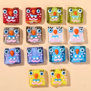 Macro detail of colorful square cartoon monster glass beads for DIY jewelry making