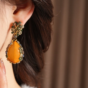 Detailed close-up of vintage dangle earrings with colorful crystals and gold metal base