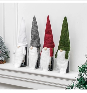 Detailed view of four felt Christmas gnome wine bottle covers in white, gray, red and green