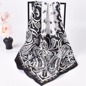 Detail of black and white paisley satin square scarf on a display stand with roses