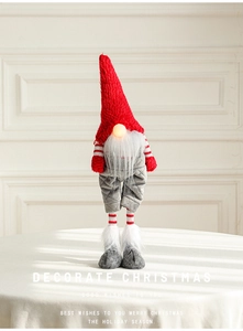 Detail of red and grey Christmas gnome with glowing nose and long knitted legs