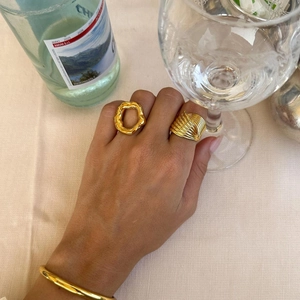 Nahaufnahme von zwei 18k vergoldeten Edelstahlringen mit Struktur am Finger des Models