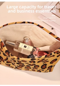 Detail view of large leopard print corduroy makeup bag filled with cosmetics
