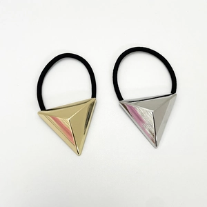 Detail of minimalist black elastic hair ties with gold and silver triangular metal accents
