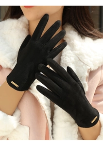 Detailed view of black suede winter gloves featuring a metal Fashion logo plaque