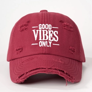 Close-up of GOOD VIBES ONLY embroidery and distressed details on a burgundy baseball cap