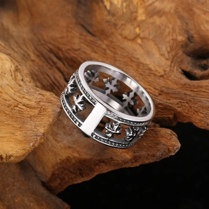 Gros plan d'une bague en acier titane argenté avec motif de feuille d'érable ajouré