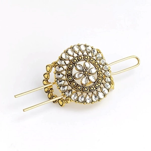 Detailed view of golden flower hair pin with turquoise accents and sparkling rhinestones